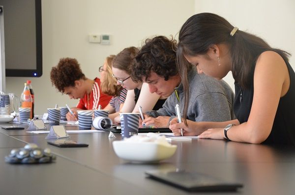 Vijf jongeren schrijven hun ideeën op.
